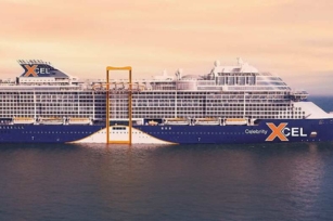 Image of the side of the Celebrity Xcel cruise ship with cloudy skies in the background