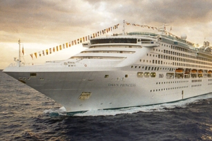 close up of the front of the Dawn Princess cruise ships cruising through the dark blue waters featuring the cloudy skies