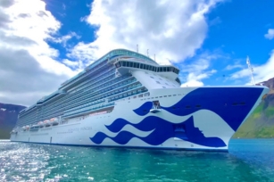 close up of the front of the Enchanted Princess cruise ship gliding through the turquoise waters  