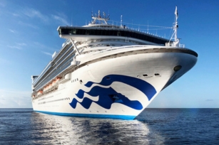 close up of the Golden Princess cruise ship gliding through the deep blue waters featuring the clear blue skies