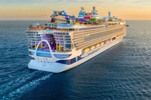 image of the back of the cruise ship of Icon of the Sea cruising through calm waters at sun rise