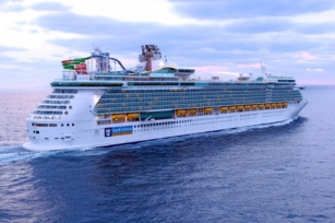 close up of the Liberty of the Seas cruise cruising along the sea against the red hue of the skies