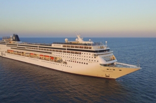 aerial view of the MSC Sinfonia as the sun sets it shines against the cruise ship on a calm night
