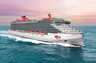 image of the Resilient Lady cruise ship cruising through the blue/green waters featuring the lit up skies